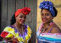 Cuban women dressed in traditional clothing selling flowers in Havana Vieja