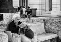 Elderly Cuban woman reading on Paseo de Marti in Havana Cuba