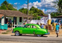 Green-Car-parked-in-front-of-Jugo-de-Cana-stand-in-Iznaga-Cuba